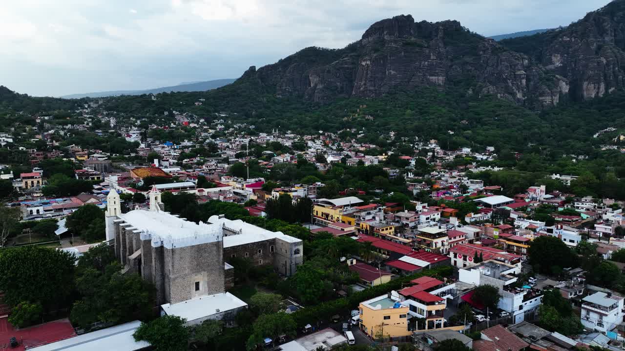 Aerial tracking shot in front of the Parroquia Nuestra Se&ntilde;ora de la Natividad in Tepoztlan, Morelos, cloudy Mexico