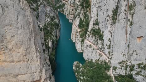 Aerial-views-of-the-Mont-Rebei-canyon-with-the-cliffs,-stairs-on-the-walls,-the-lake,-and-the-path-along-the-canyon