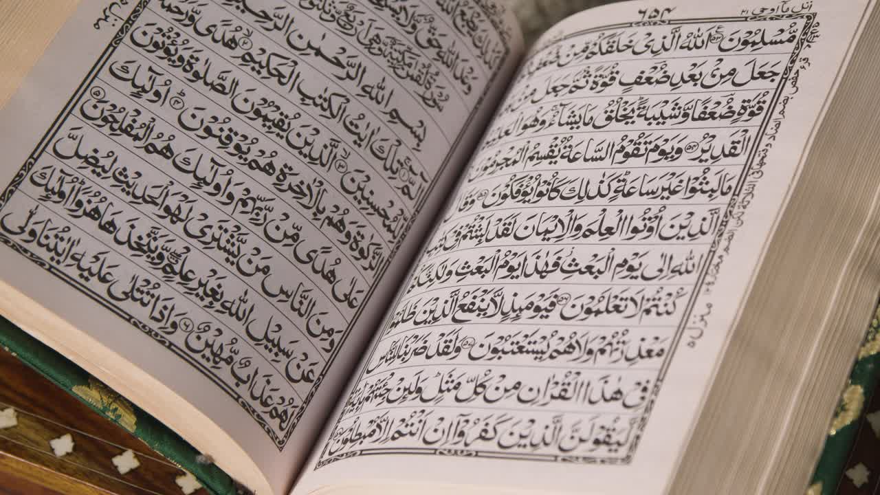 집에 있는 스탠드에 있는 꾸란의 열린 사본을 닫으세요