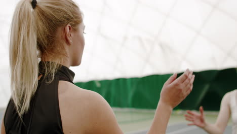 Caucasian-female-tennis-players-handshaking-at-the-tennis-court-after-match-or-practice.-4K-UHD-RAW-graded-footage