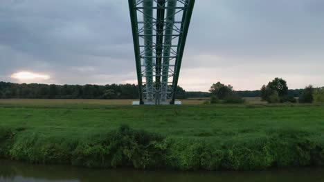 Flying-under-gas-pipe-bridge-across-calm-river-Moravia