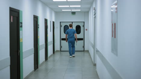 Surgeon-going-operation-room-back-view.-Doctor-walking-on-hospital-corridor