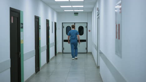 surgeon going operation room back view. doctor walking on hospital corridor