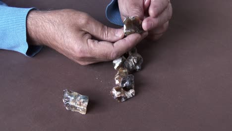 un cortador de piedras preciosas que selecciona un raro ópalo de ojo de gato africano de un paquete de áspero