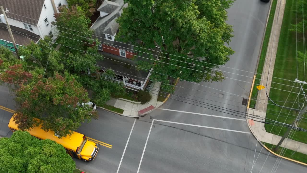 Yellow school bus driving on American town street