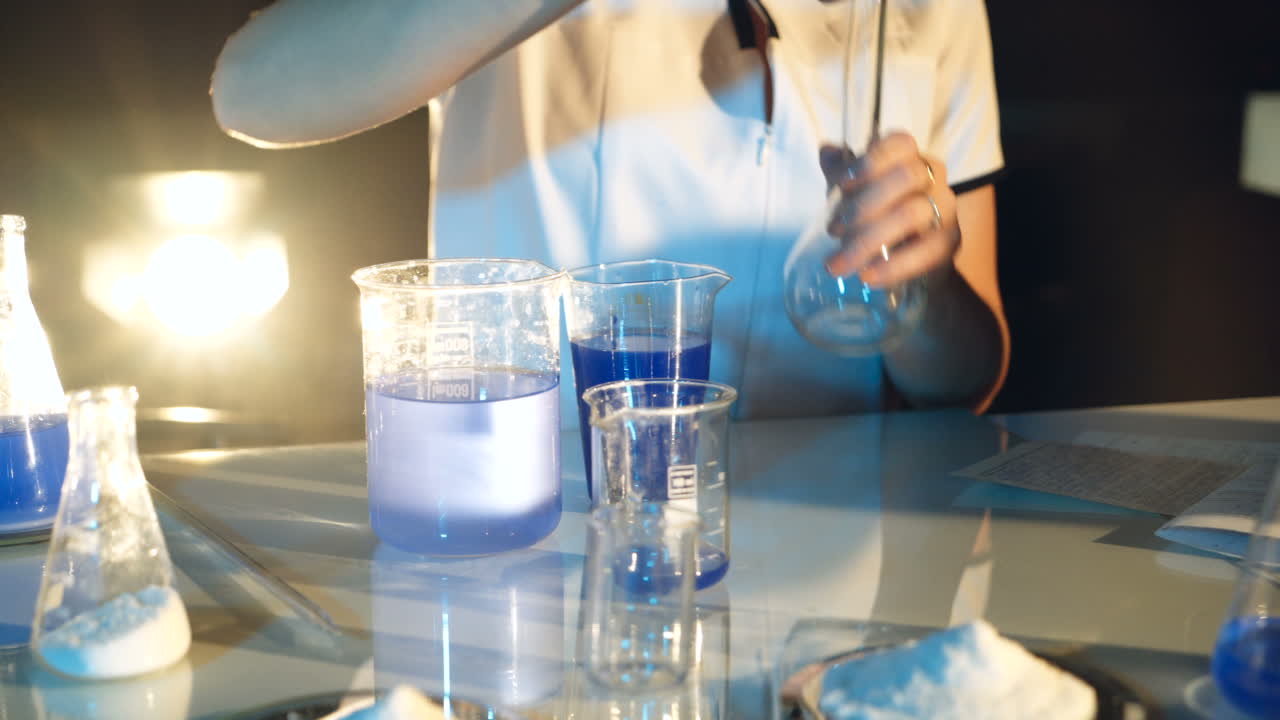 Woman scientist mixing together two liquid substances. Scientific discoveries. Experiments in the laboratory