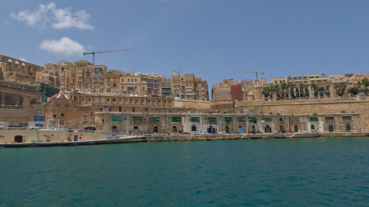 Vista dell'imponente paesaggio urbano e delle mura della città portuale di La Valletta, Malta, da una barca in acqua.