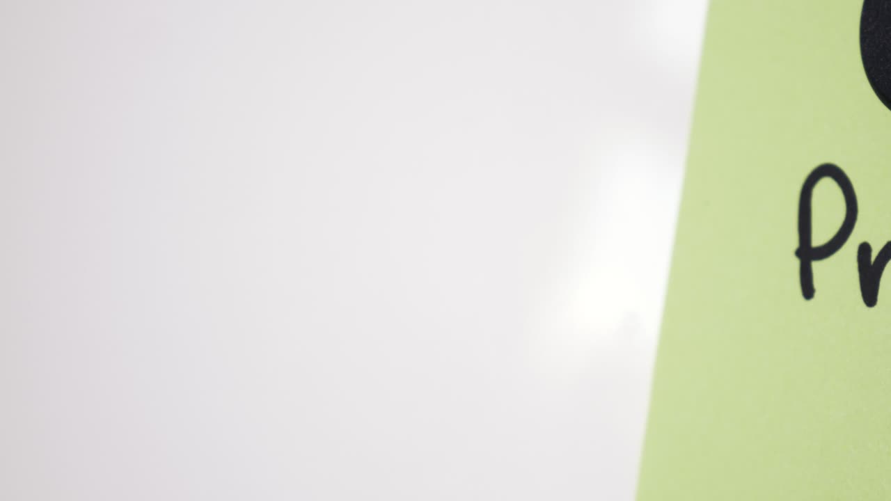 Pan reveal of Profit text on green note held by magnet on whiteboard with selective focus