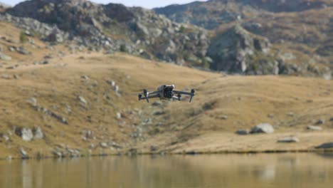 flying dji air professional drone flying suspended in static mode over mountain lake