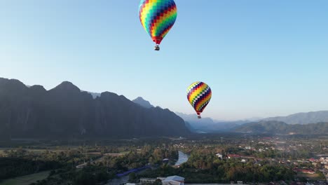 tomada de un avión no tripulado de un paseo en globo de aire caliente sobre el río en vang vieng, la capital de la aventura de laos