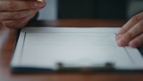 businessman hand holding pen signing report after checking information close up.