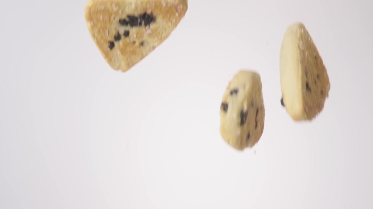 Crumbly fruit-studded scones cascading and falling through frame on white in slow motion. mothers day brunch posts, tea shop ads, weekend brunch videos.