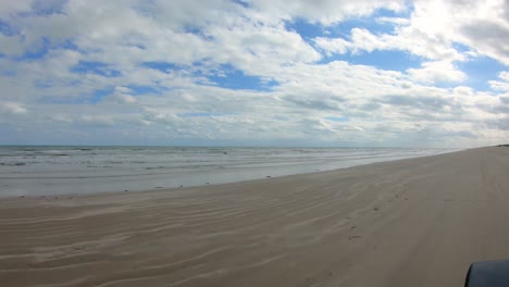 POV-thru-the-rear-window-of-vehicle-on-the-beach-on-North-Padre-Island-National-Seashore-near-Corpus-Christi-Texas-USA-on-a-partially-cloudy-day