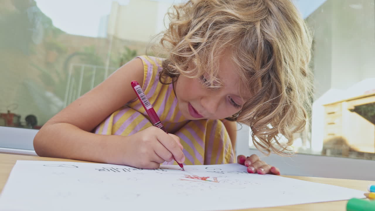 criança pequena usando canetas coloridas e papel desenhando imagens