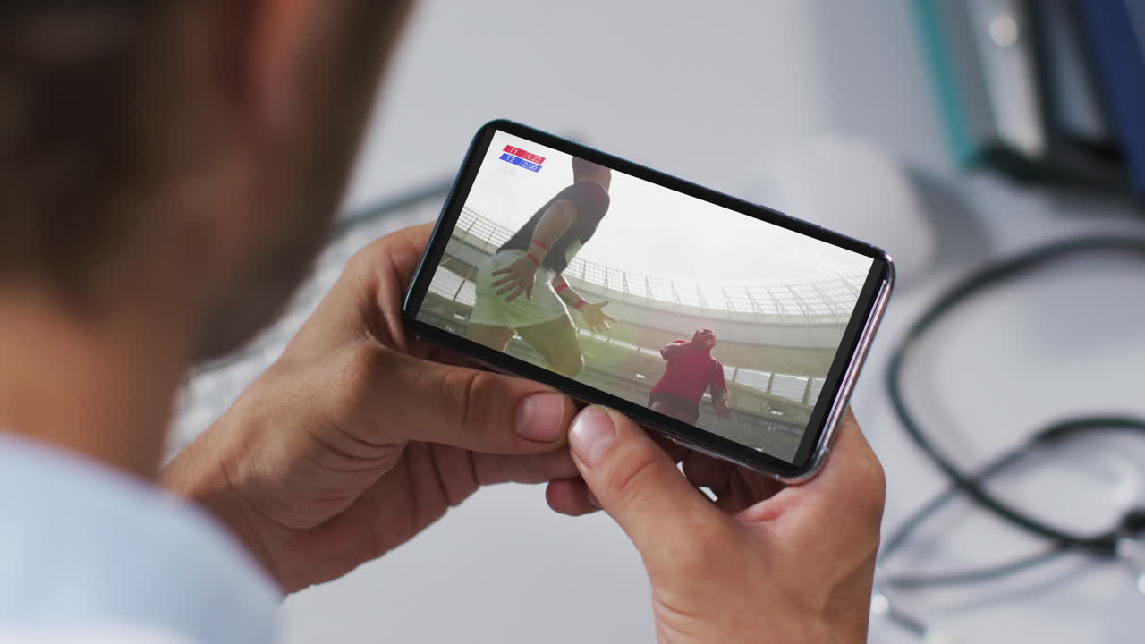 composición de un médico masculino viendo un partido de rugby en un teléfono inteligente
