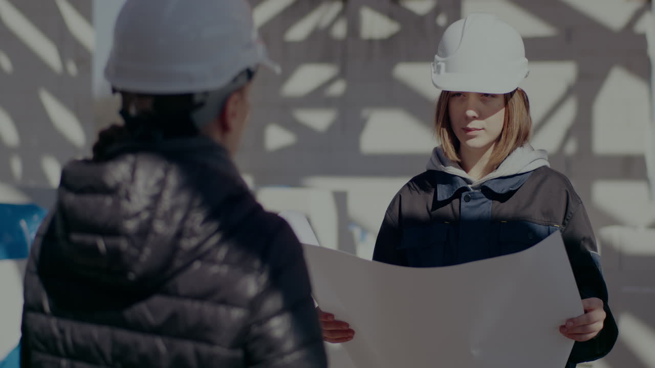 Architektka omawia projekt z wykonawcą na placu budowy