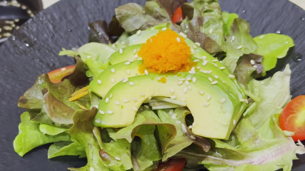 Nærbillede af en frisk avocadosalat i japansk stil, smukt anrettet med blandede grøntsager og traditionel japansk dressing. Sund og farverig salatpræsentation, der viser autentisk japansk madkultur.