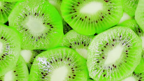 las rebanadas redondas de kiwi jugoso maduro giran lentamente.