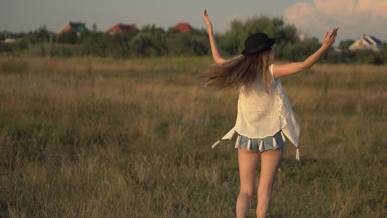 una mujer en un campo disfrutando de la puesta de sol.