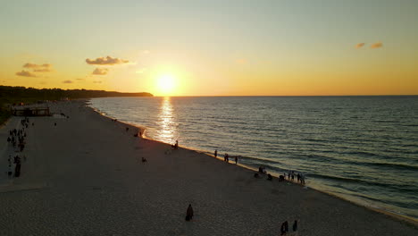 Vista-Aérea-De-Personas-Viendo-La-Hermosa-Puesta-De-Sol-En-La-Playa-En-Wladyslawowo,-Polonia