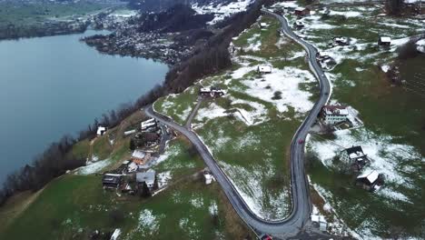 cars driving up a serpentine on a winter mountain in amden, switzerland