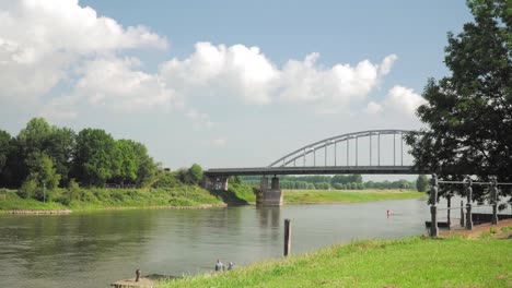 river landscape with bridge and people fishing