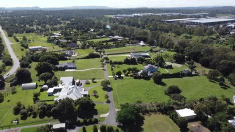 4k aerial video of a lush green rural suburb with large family homes near a small river in australia