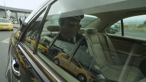 a pilot sits in a seat inside a black car that drives him