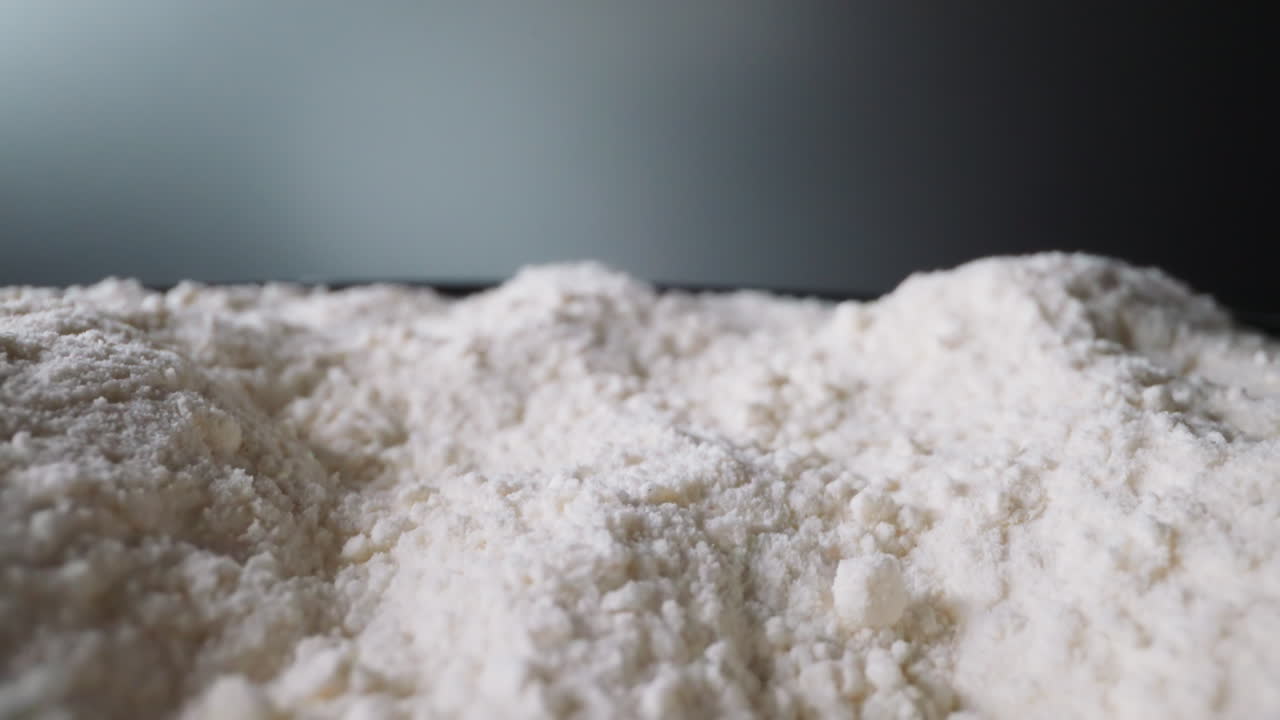 Shaken white flour moves saturating with oxygen in kitchen
