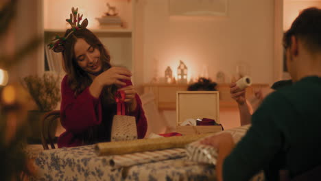 hombre y mujeres envolviendo cajas de regalos en casa