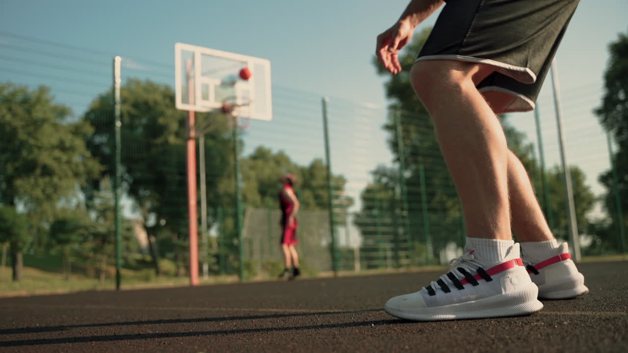 dos jugadores de baloncesto entrenando en una cancha de baloncesto al aire libre