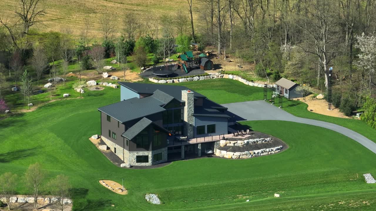 Luxury large American Villa in Rural Suburb district of USA. Sunny day with green groomed garden. Aerial orbiting shot.