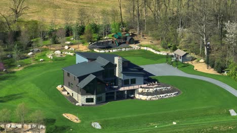 luxury large american villa in rural suburb district of usa. sunny day with green groomed garden. aerial orbiting shot.