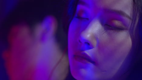 close up of a couple listening to music in neon lights