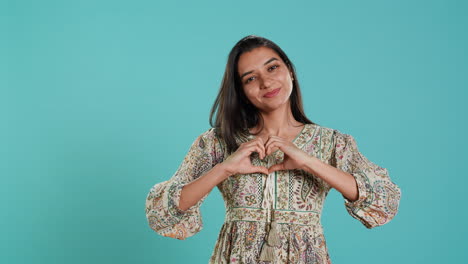 Retrato-De-Una-Mujer-Alegre-Y-Amigable-Haciendo-Un-Gesto-Con-Forma-De-Símbolo-De-Corazón