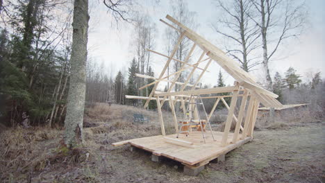 timber structure of unfinished off grid tiny house project in woods, slider