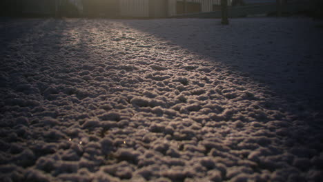 Toma-Amplia-De-Nieve-En-El-Jardín,-Sol-Golpeando-Partes-De-La-Nieve-Creando-Un-Foco-De-Luz