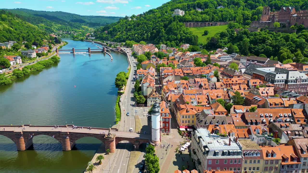 4K Aerial Drone Video of Historic Heiliggeistkirche Church on Neckar River with Castle on Königstuhl Hill overlooking Heidelberg, Germany