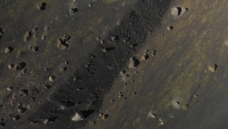 birdseye view of the ground with rocks and black sand drone shot in iceland