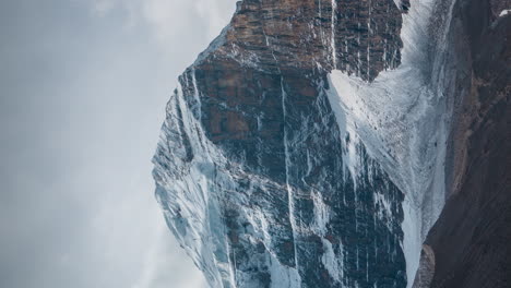 vertical 4k time lapse, cold freezing landscape, clouds moving above rocky hills and glacier ice