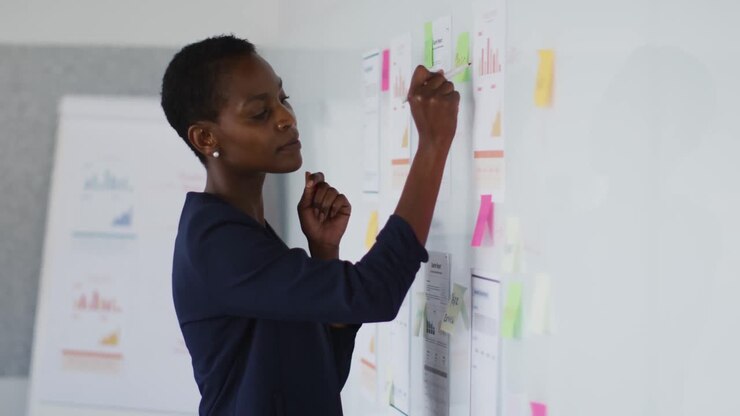 African american businesswoman thinking and making notes at work