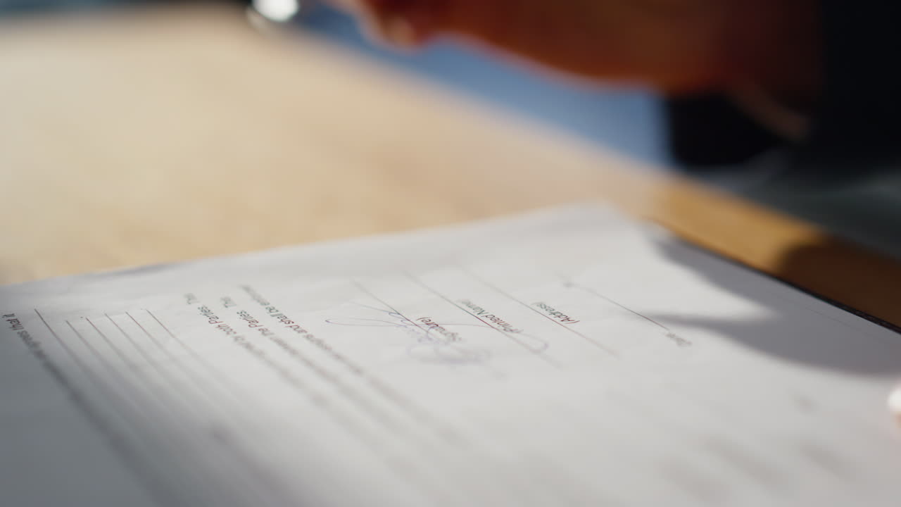 Businessman hand signing agreement at office desk closeup. Man putting signature