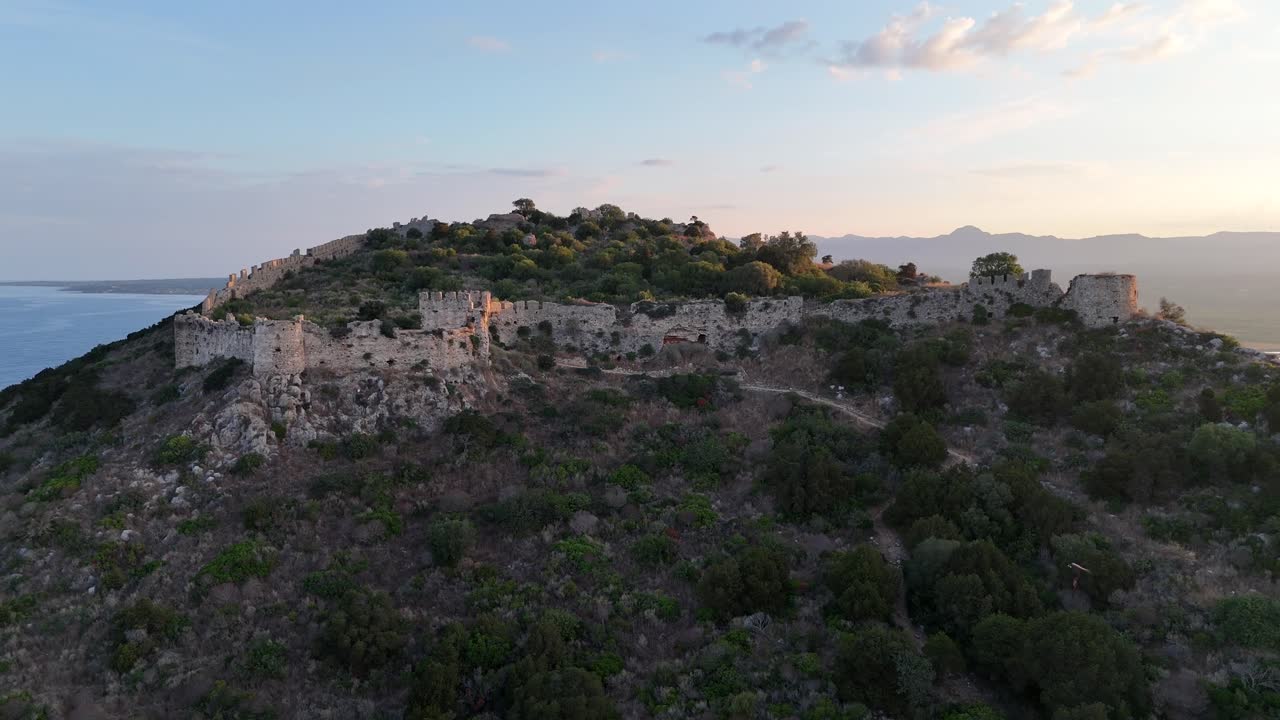 Pylos,Messinia,Peloponnese, Aerial view circle pan left around Navarino Castle on top of the mountain by the Mediterranean Sea during sunrise,background is the colorful sky and clouds
