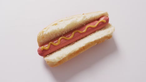 Video-of-hot-dog-with-mustard-on-a-white-surface