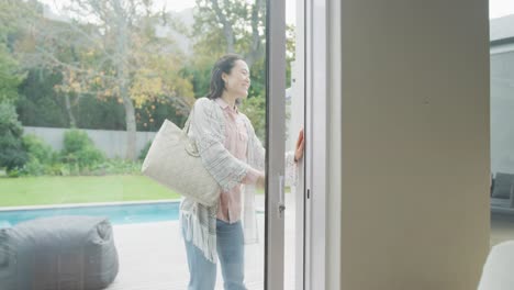 feliz hija adulta asiática llegando y abrazando con la madre en la puerta desde el jardín