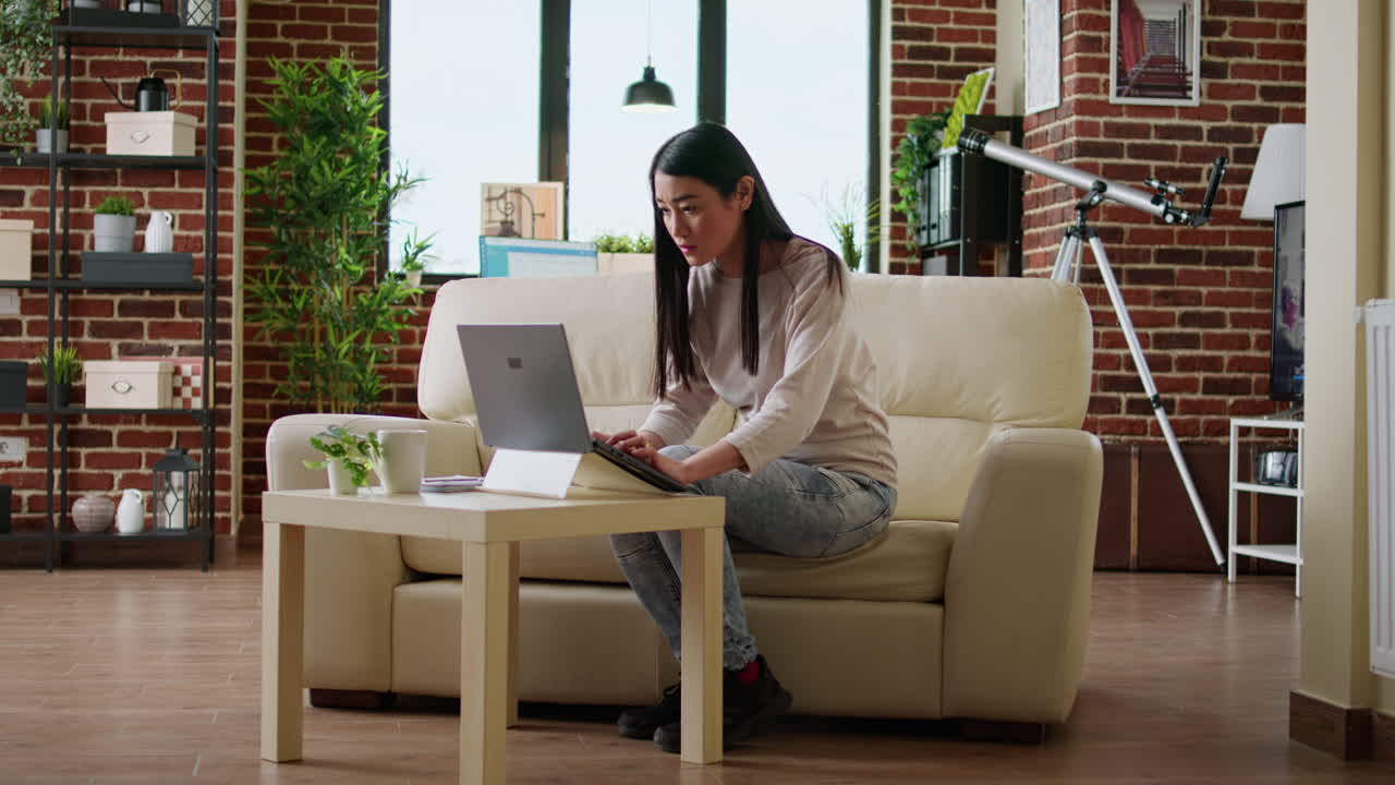 Woman working on laptop in living room