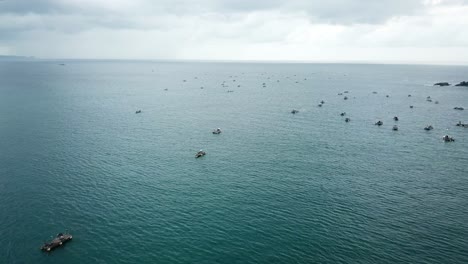 aerial 4k floating lobster traps and fishing boats on horizon, indonesia