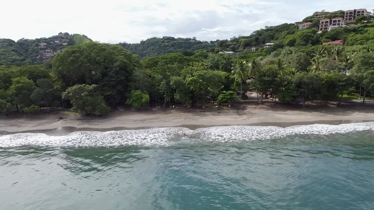 niña saliendo del agua en una playa con poca gente en costa rica