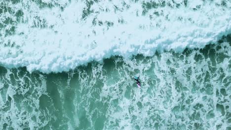 surfer catching a wave from above. birds-eye-view shot