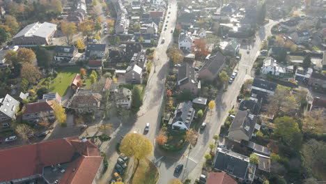 aerial of cars driving over streets in a beautiful suburban neighborhood in autumn